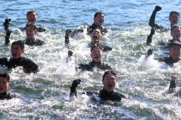 Bei Minusgraden singen Taucher der südkoreanischen Marine, während sie im eiskalten Meerwasser vor der Stadt Changwon schwimmen.