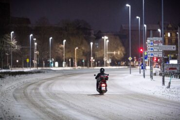 Motorroller kämpft sich am frühen Morgen durch Schnee im Stadtzentrum in Hannover