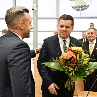 Sven Schulze bekommt Glückwünsche und einen Blumenstrauß vom AfD-Spitzenkandidaten Ulrich Siegmund.