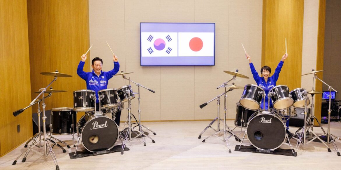 Die japanische Ministerpräsidentin Sanae Takaichi (r) und der südkoreanische Präsident Lee Jae Myung spielen Schlagzeug.