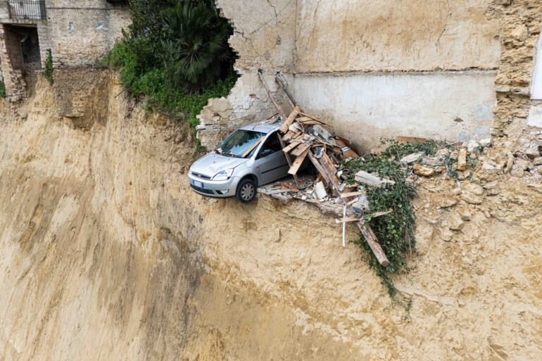 Nach dem schweren Erdrutsch auf Sizilien hängt ein Auto über einem Abgrund.