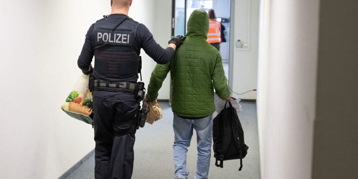 Ein Polizeibeamter bringt einen Mann zu einem Abschiebeflug nach Pakistan. (Archivfoto)