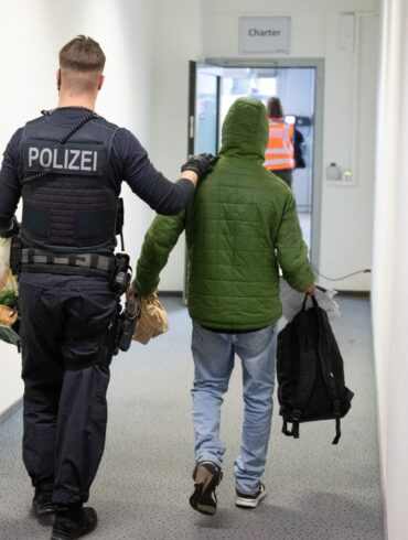 Ein Polizeibeamter bringt einen Mann zu einem Abschiebeflug nach Pakistan. (Archivfoto)