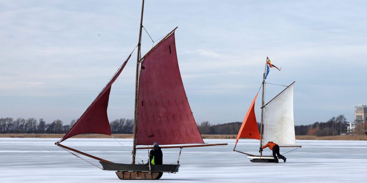 Eissegler sind auf dem zugefrorenen Bodden bei Wustrow auf der Halbinsel Fischland unterwegs.