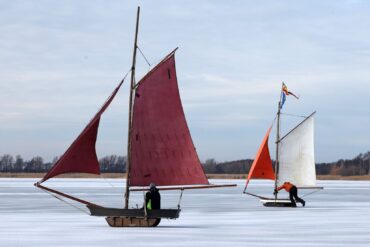 Eissegler sind auf dem zugefrorenen Bodden bei Wustrow auf der Halbinsel Fischland unterwegs.