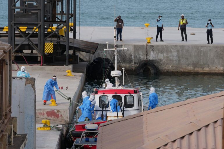 Gesundheitspersonal in Schutzkleidung evakuiert Patienten vom Kreuzfahrtschiff «Hondius» in einem Hafen.