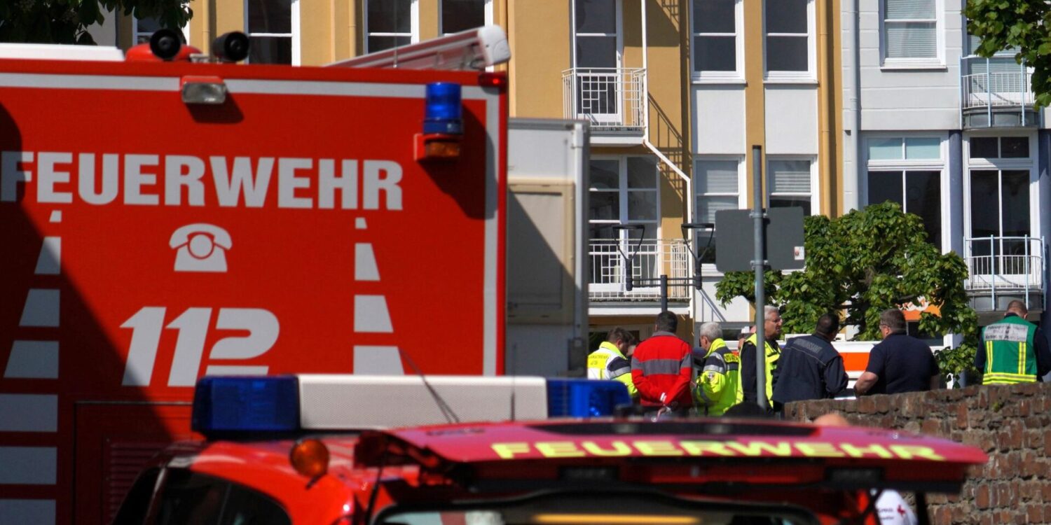 Rettungswagen, Polizisten und Polizeifahrzeuge stehen in der Nähe des Einsatzortes.