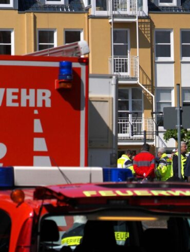Rettungswagen, Polizisten und Polizeifahrzeuge stehen in der Nähe des Einsatzortes.