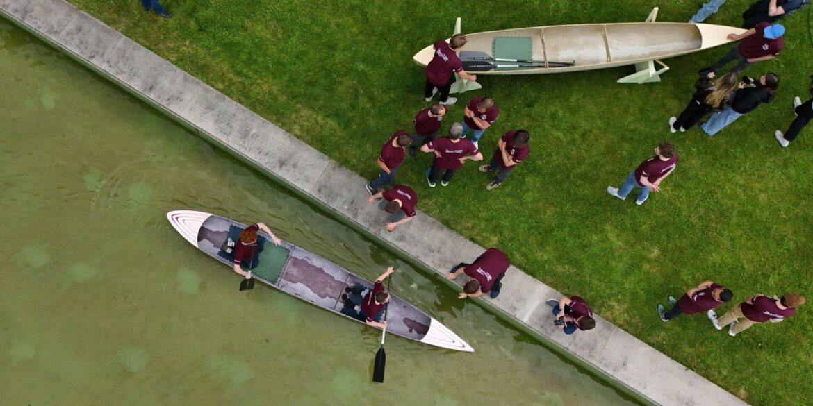 Studenten und Studentinnen der Bauhaus-Universität Weimar fahren mit dem Betonkanu auf dem Wasser im Weimarer Schwanseebad. (Aufnahme mit einer Drohne)