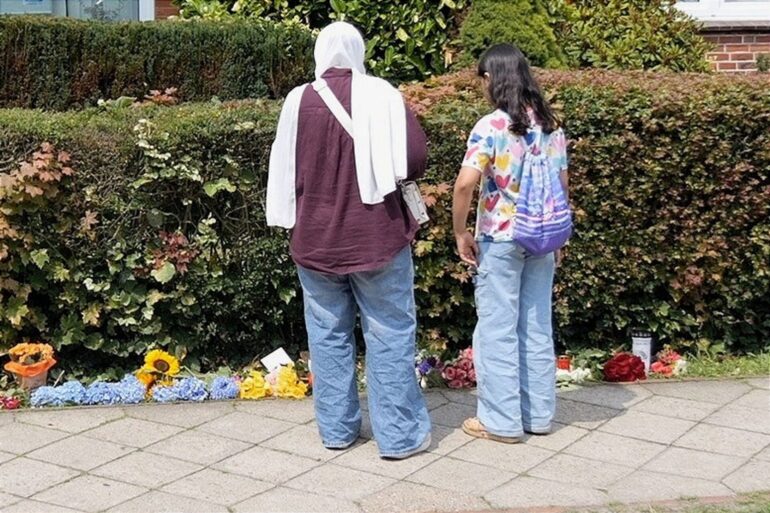 Blumen und Kerzen stehen und liegen am Tatort.