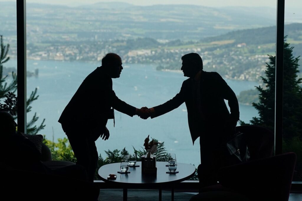 Mitarbeiter der Delegationen geben sich im Rahmen eines Treffens zwischen den USA, dem Iran, Pakistan und Katar die Hand.