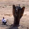 Ein Mann betrachtet das Wrack einer Rakete, die nach einem iranischen Angriff im Westjordanland aus dem Boden ragt.