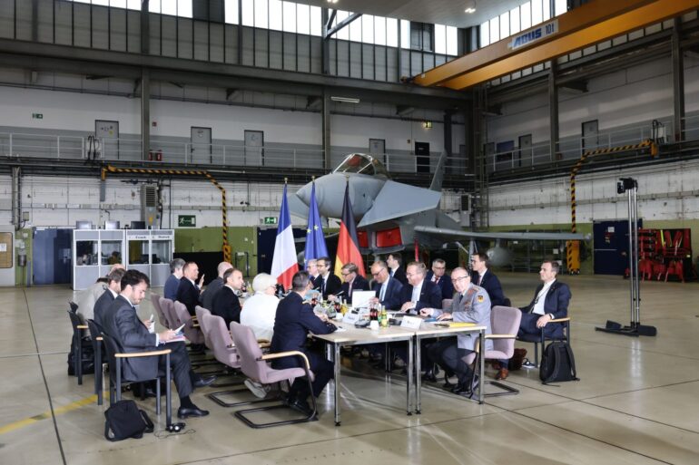 In einer Wartungshalle auf dem Militärflugplatz Nörvenich tagt der deutsch-französische Verteidigungs- und Sicherheitsrat.