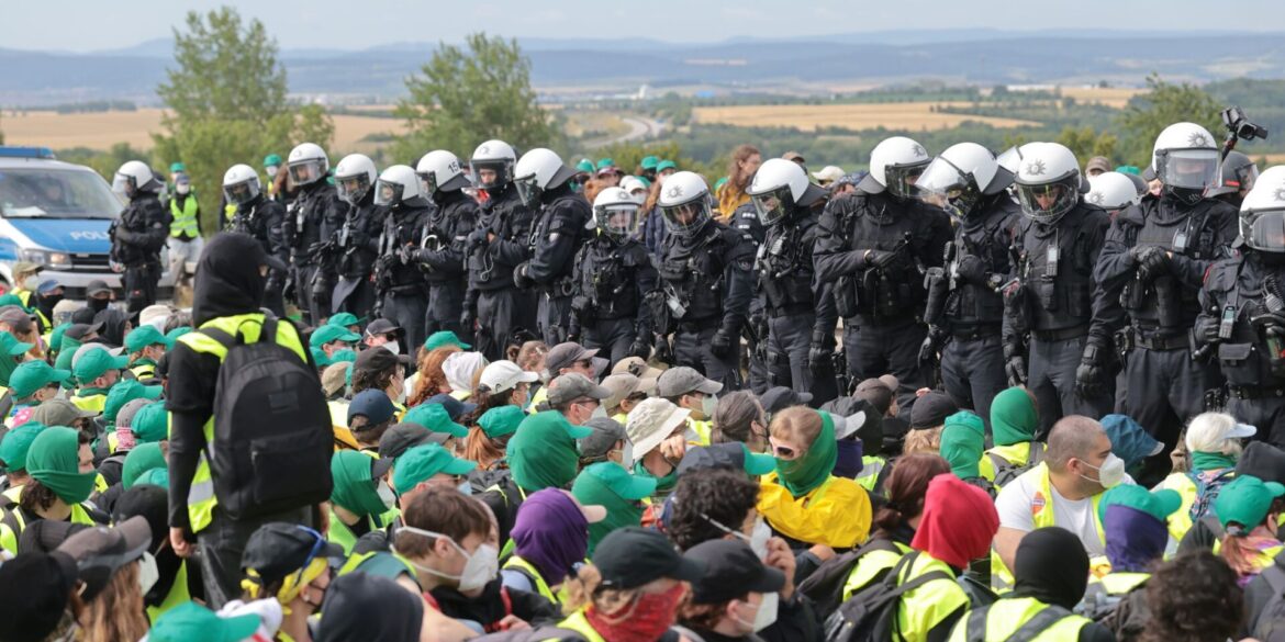 Eine Sitzblockade auf der Autobahn 71 - Polizisten umringen die Demonstranten.
