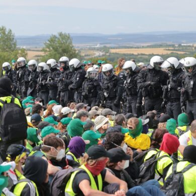 Eine Sitzblockade auf der Autobahn 71 - Polizisten umringen die Demonstranten.