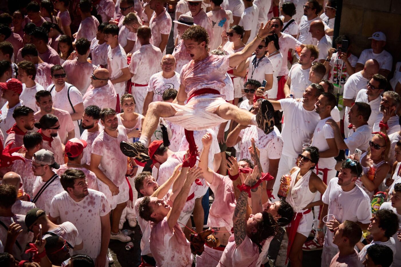 Ausgelassen feiern die Menschen kurz vor dem Chupinazo beim San-Fermín-Fest 2026 auf der Plaza del Ayuntamiento. Der Chupinazo ist der offizielle Beginn der San-Fermín-Feierlichkeiten,