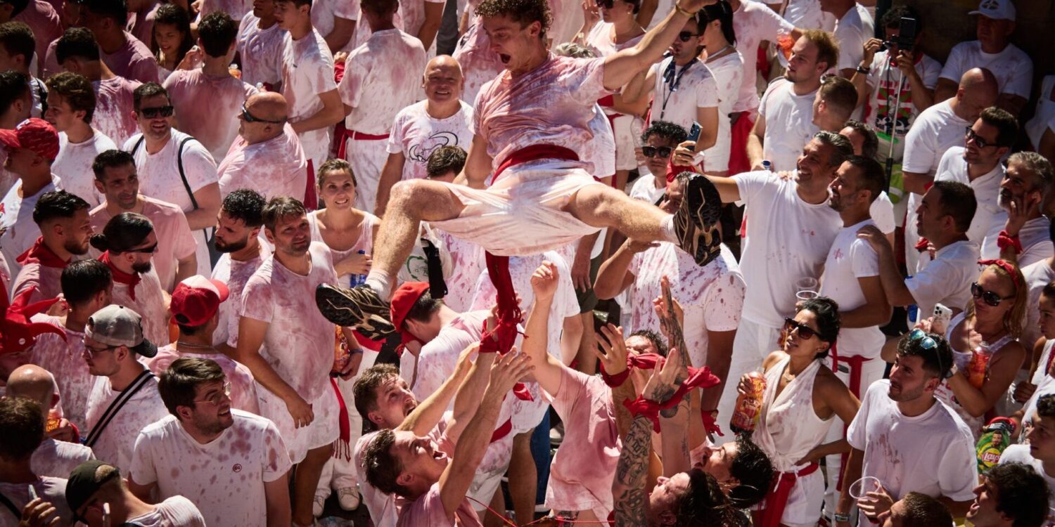 Ausgelassen feiern die Menschen  kurz vor dem Chupinazo beim San-Fermín-Fest 2026 auf der Plaza del Ayuntamiento. Der Chupinazo  ist der offizielle Beginn der San-Fermín-Feierlichkeiten,