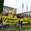 Vertreter mehrerer Städte und Kommunen demonstrieren mit Schildern und Bannern für finanzielle Unterstützung in Berlin.
