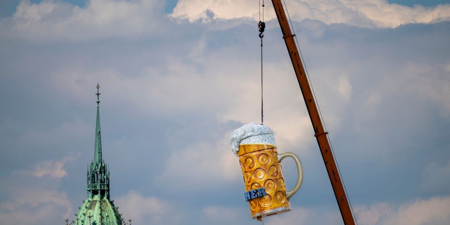 Ein übergroßer und rund 1,5 Tonnen schwerer Bierkrug wird mit einem Kran auf der Theresienwiese an seinen Platz gehoben. Das 191. Oktoberfest beginnt dieses Jahr am 19. September 2026 und endet am 04. Oktober 2026.