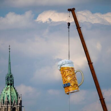 Ein übergroßer und rund 1,5 Tonnen schwerer Bierkrug wird mit einem Kran auf der Theresienwiese an seinen Platz gehoben. Das 191. Oktoberfest beginnt dieses Jahr am 19. September 2026 und endet am 04. Oktober 2026.