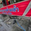 Vor einem Pub in Bangkok liegen nach einem Brand verstreute Schuhe.