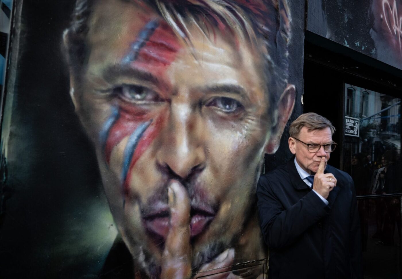 Der deutsche Außenminister Johann Wadephul (CDU) steht bei einem Rundgang durch das Stadtzentrum von Buenos Aires neben einem Graffiti von David Bowie.