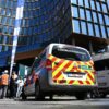 Einsatzkräfte stehen vor dem Gebäude bei einem Brand in der Brüsseler Innenstadt.