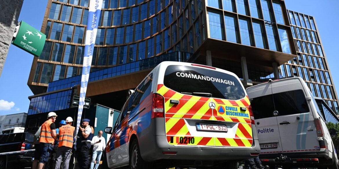 Einsatzkräfte stehen vor dem Gebäude bei einem Brand in der Brüsseler Innenstadt.
