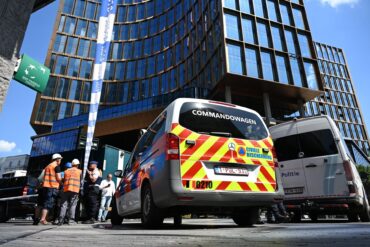 Einsatzkräfte stehen vor dem Gebäude bei einem Brand in der Brüsseler Innenstadt.