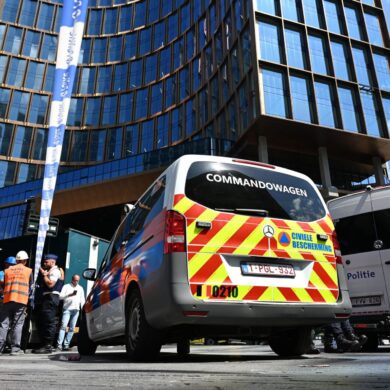 Einsatzkräfte stehen vor dem Gebäude bei einem Brand in der Brüsseler Innenstadt.