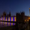 Der Westminster-Palast in London ist blau-gelb beleuchtet.