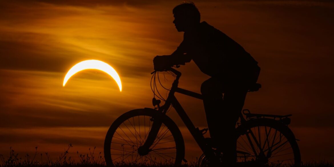Ein Junge auf einem Fahrrad betrachtet die partielle Sonnenfinsternis in Jacobsdorf, im östlichen Brandenburg.