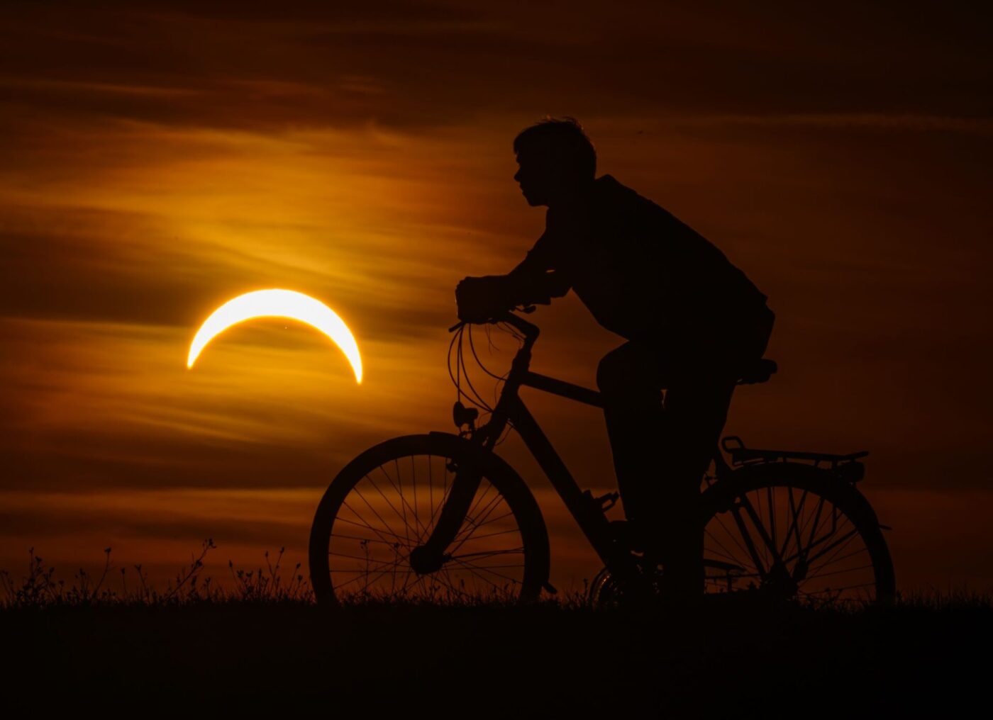 Ein Junge auf einem Fahrrad betrachtet die partielle Sonnenfinsternis in Jacobsdorf, im östlichen Brandenburg.