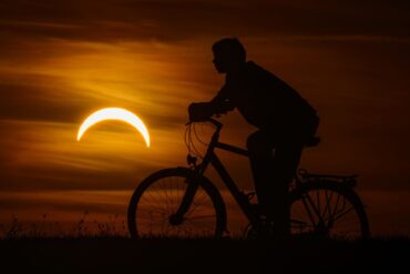 Ein Junge auf einem Fahrrad betrachtet die partielle Sonnenfinsternis in Jacobsdorf, im östlichen Brandenburg.