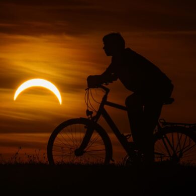 Ein Junge auf einem Fahrrad betrachtet die partielle Sonnenfinsternis in Jacobsdorf, im östlichen Brandenburg.