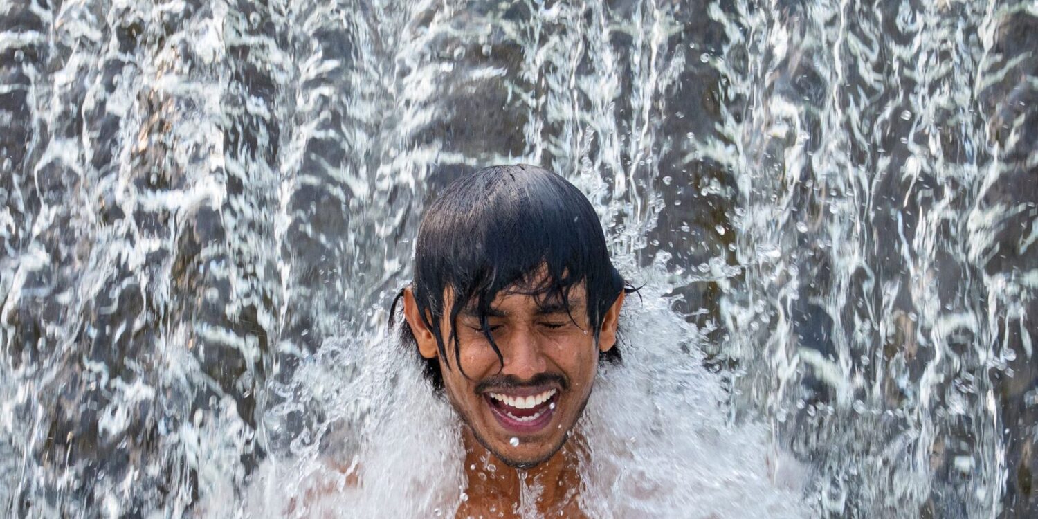 Ein Gastarbeiter aus Sri Lanka kühlt sich an einem glühend heißen Tag in einer Wasserkaskade eines Flusses außerhalb der Stadt Bragadiru in Rumänien ab.