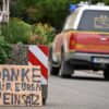 Ein Fahrzeug der Feuerwehr fährt an einem Schild mit der Aufschrift "Danke für Euren Einsatz" beim Waldbrand im Hürtgenwald vorbei.