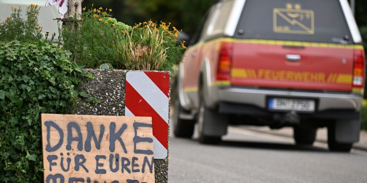 Ein Fahrzeug der Feuerwehr fährt an einem Schild mit der Aufschrift "Danke für Euren Einsatz" beim Waldbrand im Hürtgenwald vorbei.