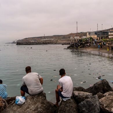 Migranten blickten von Felsen aus, während andere aus der spanischen Enklave Ceuta nach Marokko zurückkehrten.