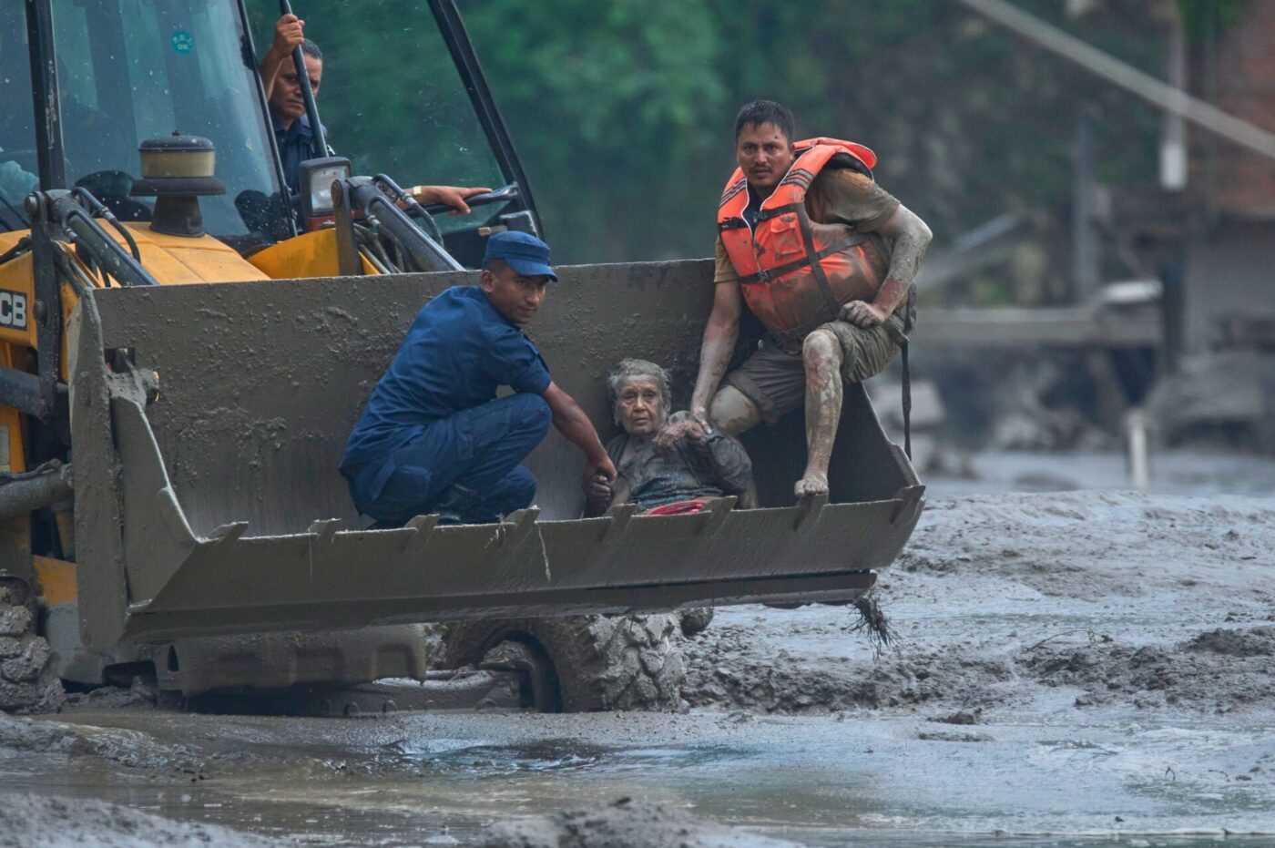 Rettungskräfte setzen am Trishuli-Fluss einen Radlader ein, um ein Opfer der Sturzflut in Sicherheit zu bringen.
