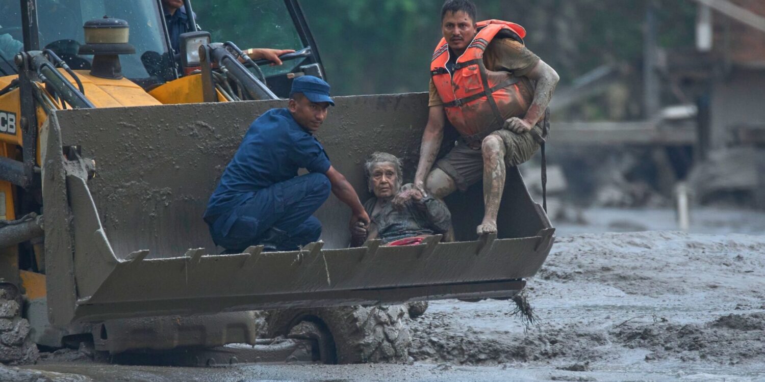 Rettungskräfte setzen am Trishuli-Fluss einen Radlader ein, um ein Opfer der Sturzflut in Sicherheit zu bringen.