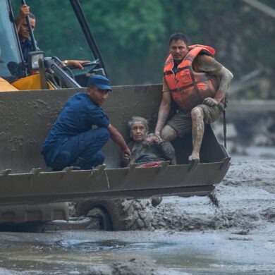 Rettungskräfte setzen am Trishuli-Fluss einen Radlader ein, um ein Opfer der Sturzflut in Sicherheit zu bringen.