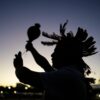 Ein indigener Mann führt während einer Demonstration ein Ritual durch.