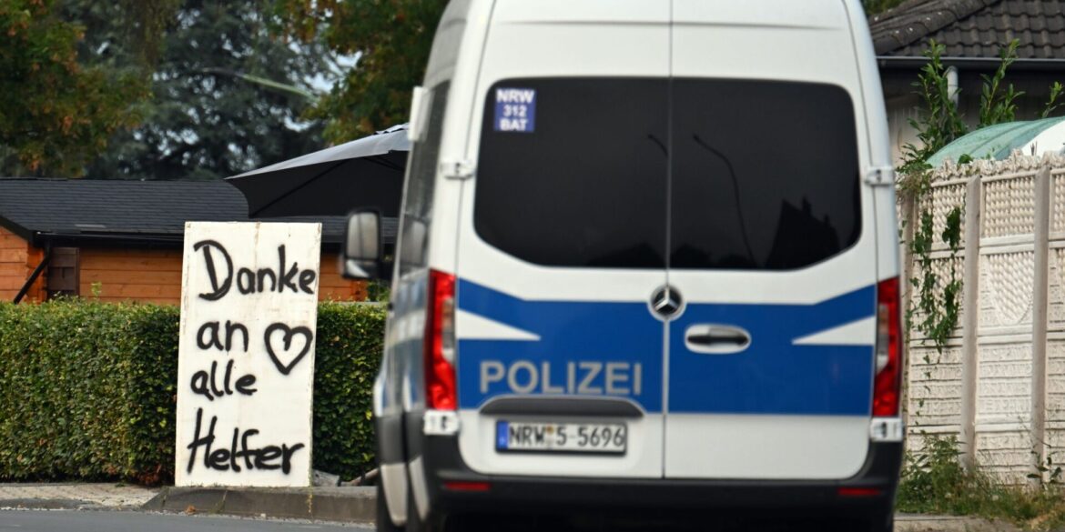 Ein Polizeifahrzeug fährt an einem Schild mit der Aufschrift «Danke an alle Helfer» vorbei.