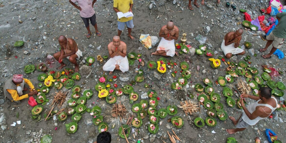 Menschen, deren Angehörige nach den Sturzfluten weiterhin vermisst werden, vollziehen am Ufer des angeschwollenen Trishuli-Flusses im nepalesischen Distrikt Nuwakot Rituale im Anschluss an symbolische Bestattungszeremonien.