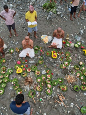 Menschen, deren Angehörige nach den Sturzfluten weiterhin vermisst werden, vollziehen am Ufer des angeschwollenen Trishuli-Flusses im nepalesischen Distrikt Nuwakot Rituale im Anschluss an symbolische Bestattungszeremonien.