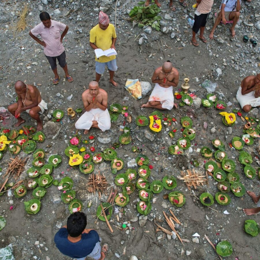 Menschen, deren Angehörige nach den Sturzfluten weiterhin vermisst werden, vollziehen am Ufer des angeschwollenen Trishuli-Flusses im nepalesischen Distrikt Nuwakot Rituale im Anschluss an symbolische Bestattungszeremonien.