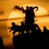 Die Sonne geht am Abend hinter der Pantherquadriga der Semperoper in Dresden unter.