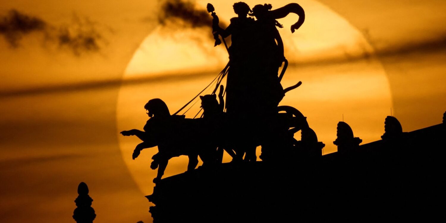 Die Sonne geht am Abend hinter der Pantherquadriga der Semperoper in Dresden unter.