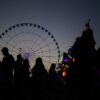 Besucher zeichnen sich vor einem Riesenrad auf dem Cannstatter Volksfest ab.